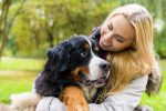 Woman embracing her dog in autumn park